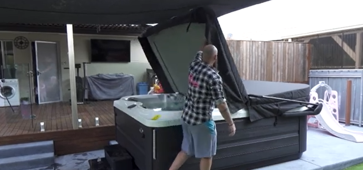 Man lifting a Jacuzzi spa cover