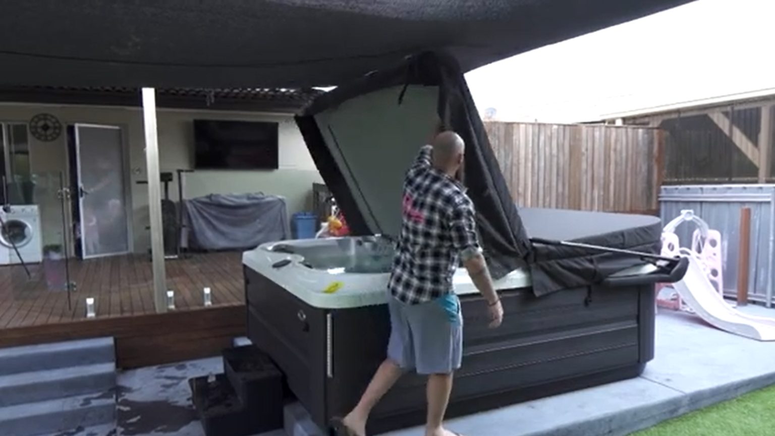 man lifting a jacuzzi spa cover