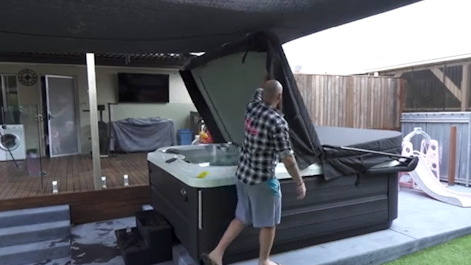 Man lifting a Jacuzzi spa cover