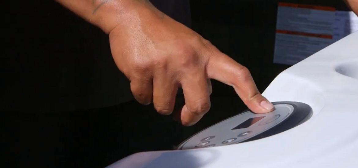 man operating jacuzzi j-200 keypad