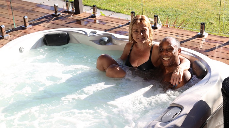 Couple smiling in Jacuzzi® J-345™ hot tub