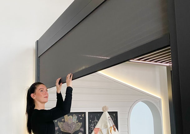 A woman adjusting the Vortex pergola zip track blind