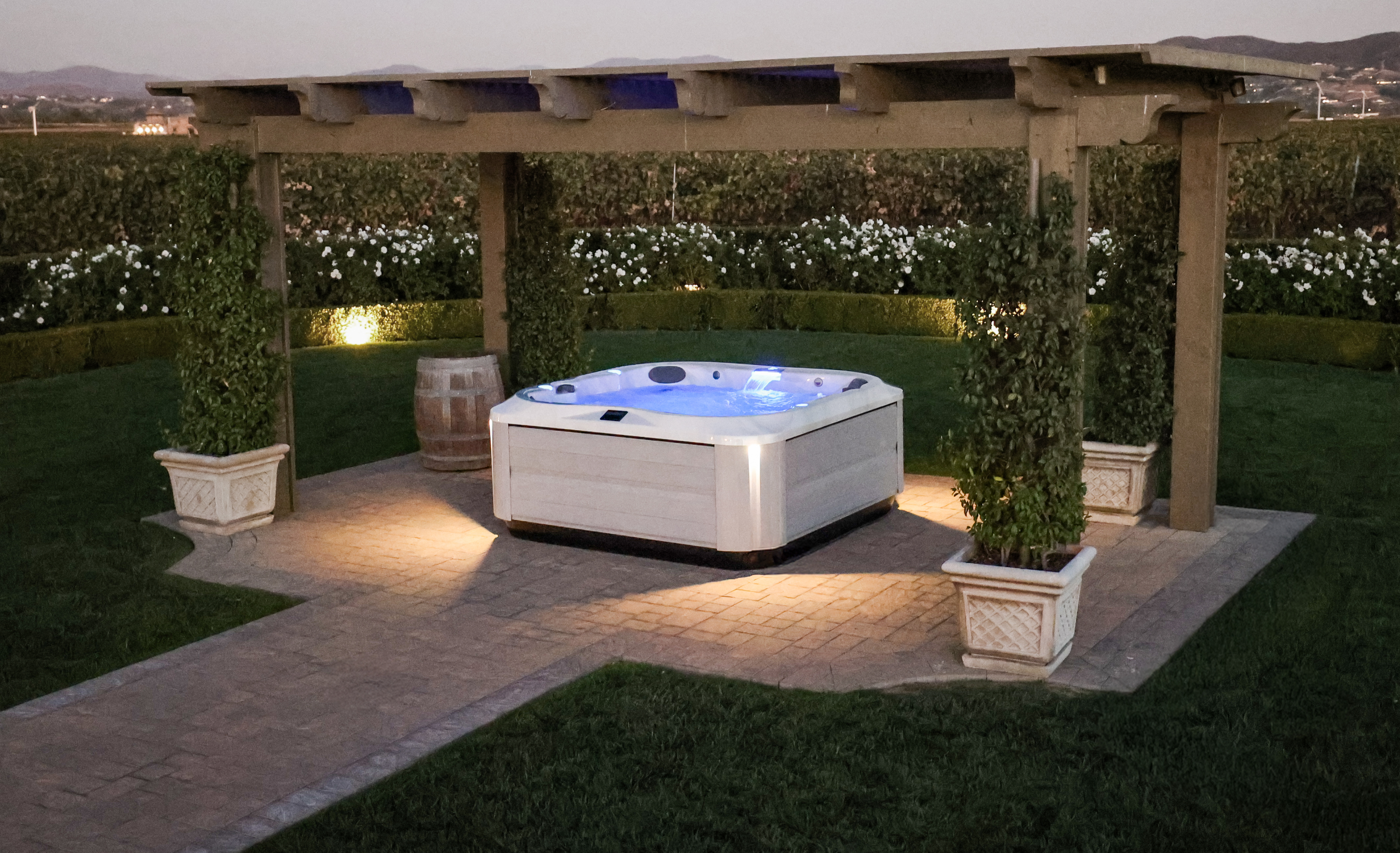 J-385 hot tub under a gazebo in a beautiful garden