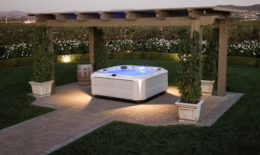 J-385 hot tub under a gazebo in a beautiful garden