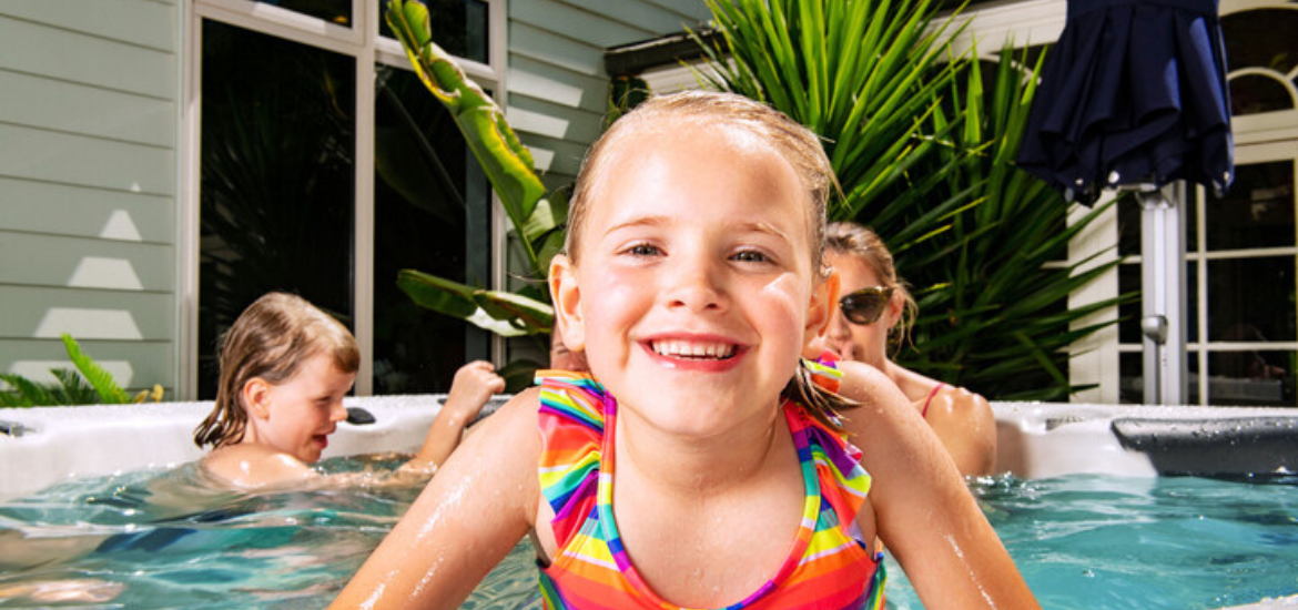 A girl happily smiling in a spa pool with her family