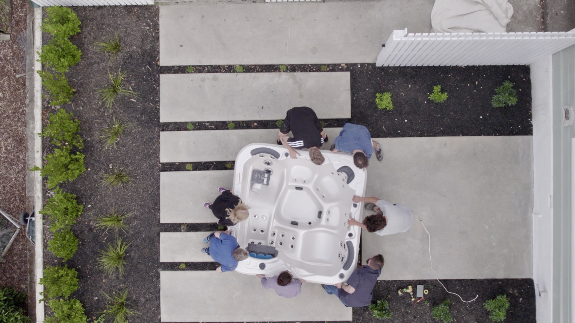 Top view of people carrying a spa pool to be installed