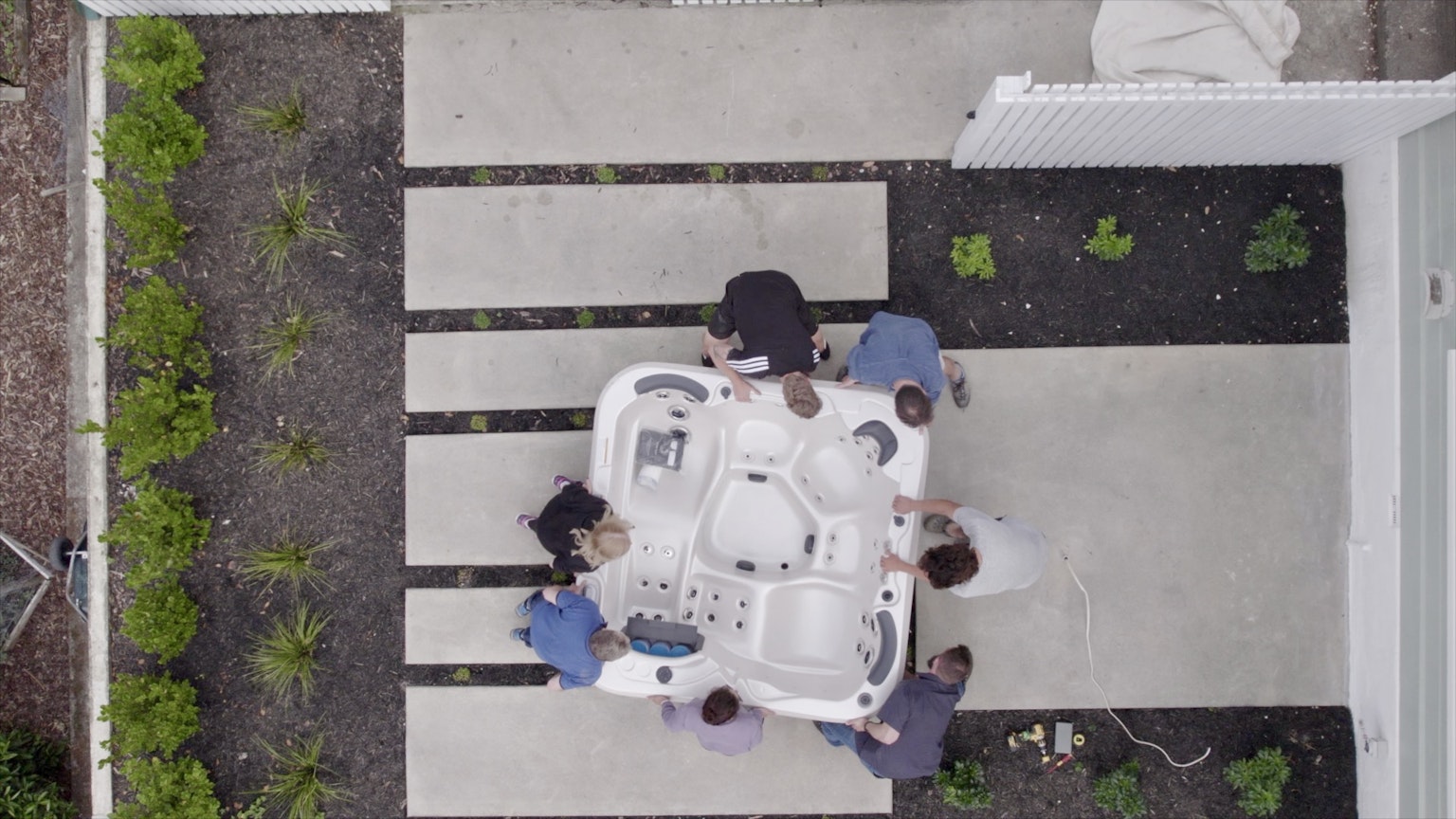 Top view of people carrying a spa pool to be installed