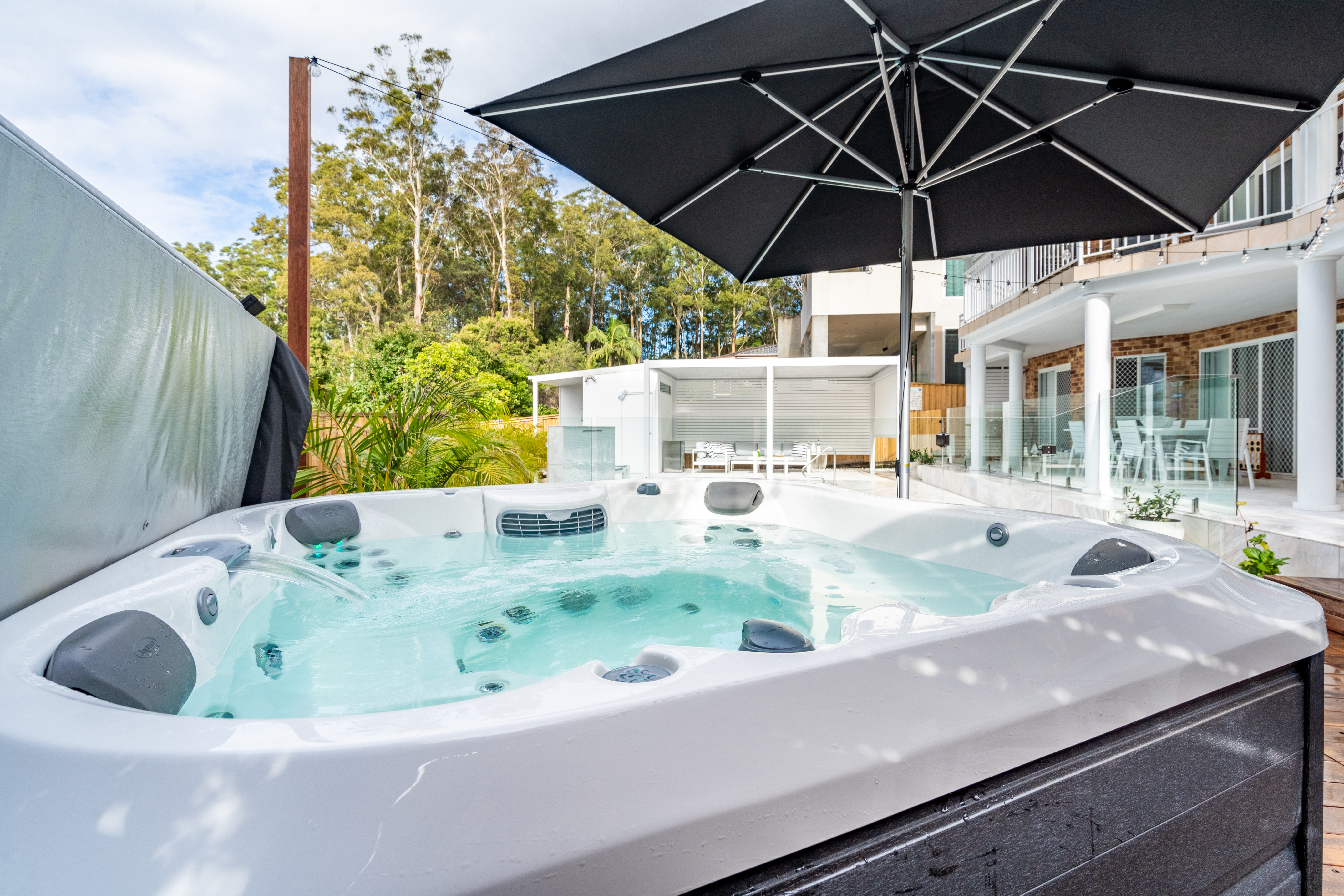 spa beside the pool beneath an umbrella