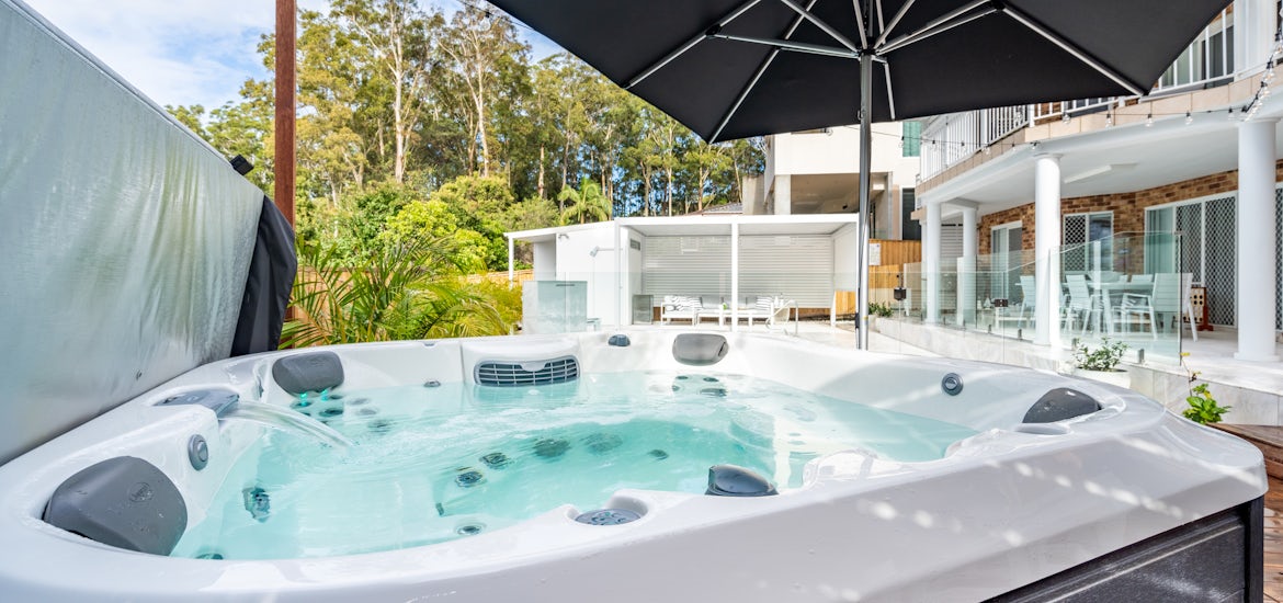 spa beside the pool beneath an umbrella