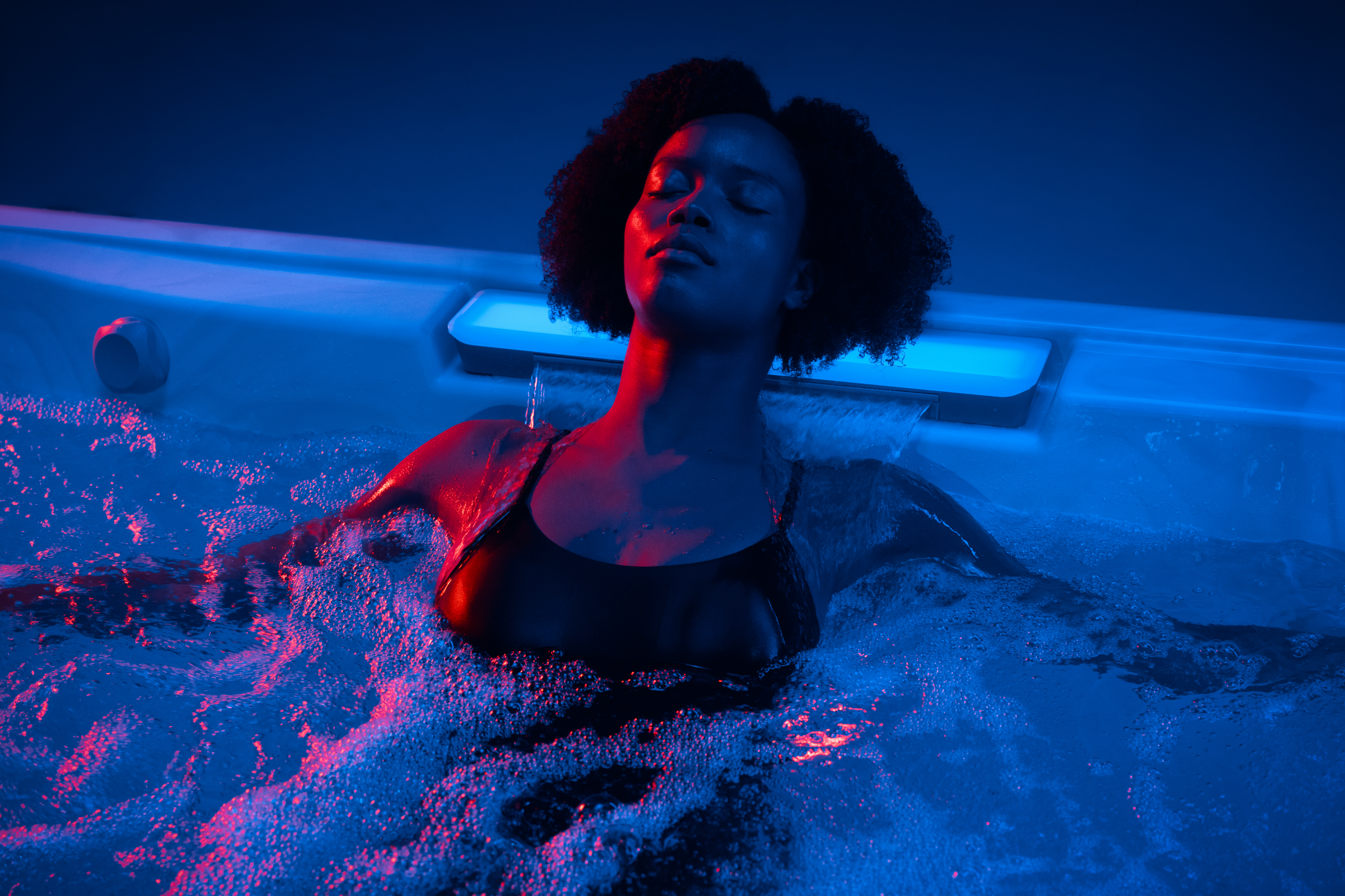 Woman using the waterfall feature of the J509™ hot tub