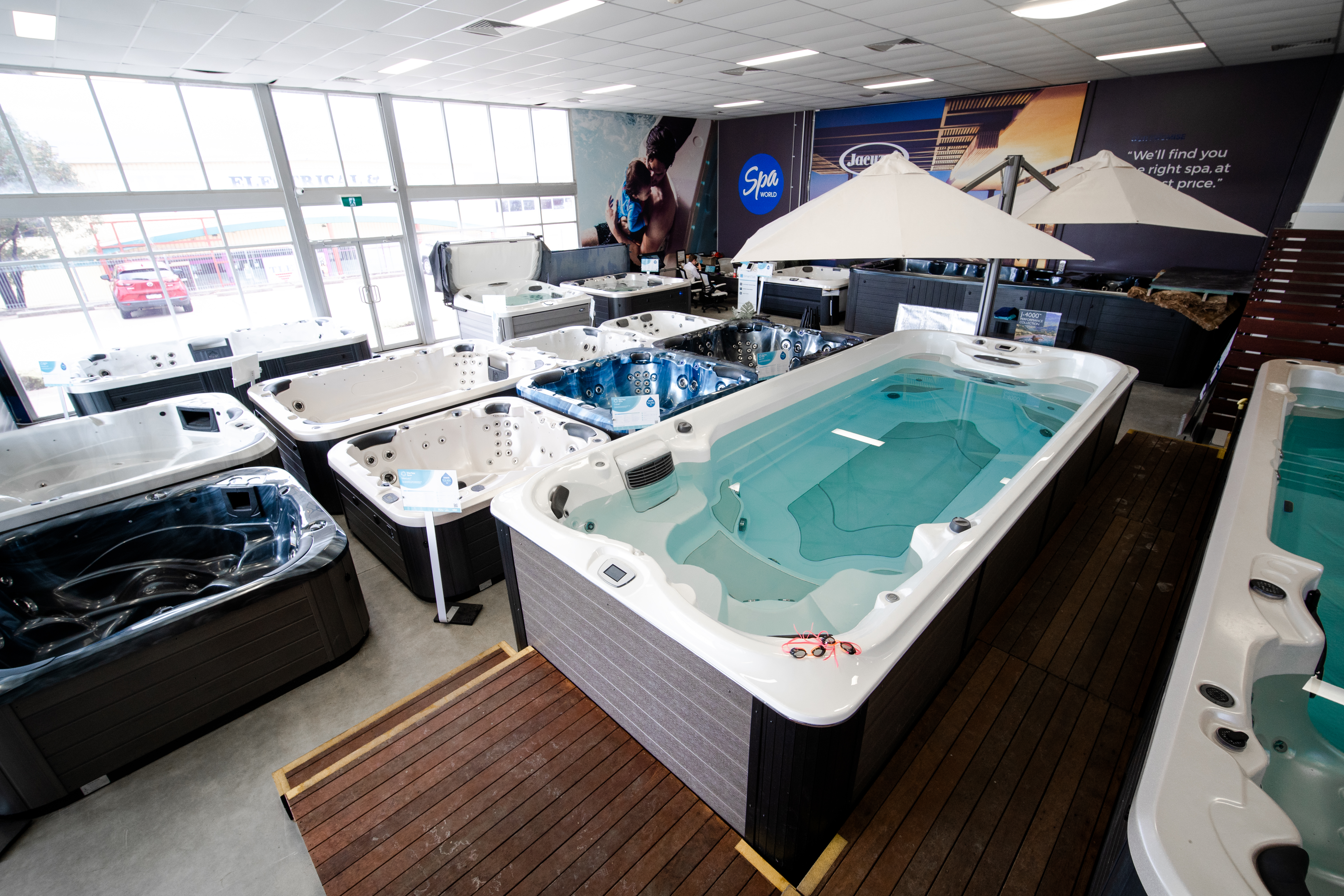 Swim spas and umbrellas on display at the Spa World Canberra showroom
