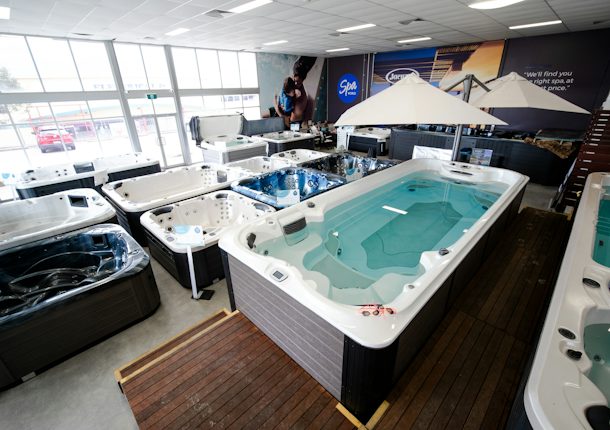 Swim spas and umbrellas on display at the Spa World Canberra showroom