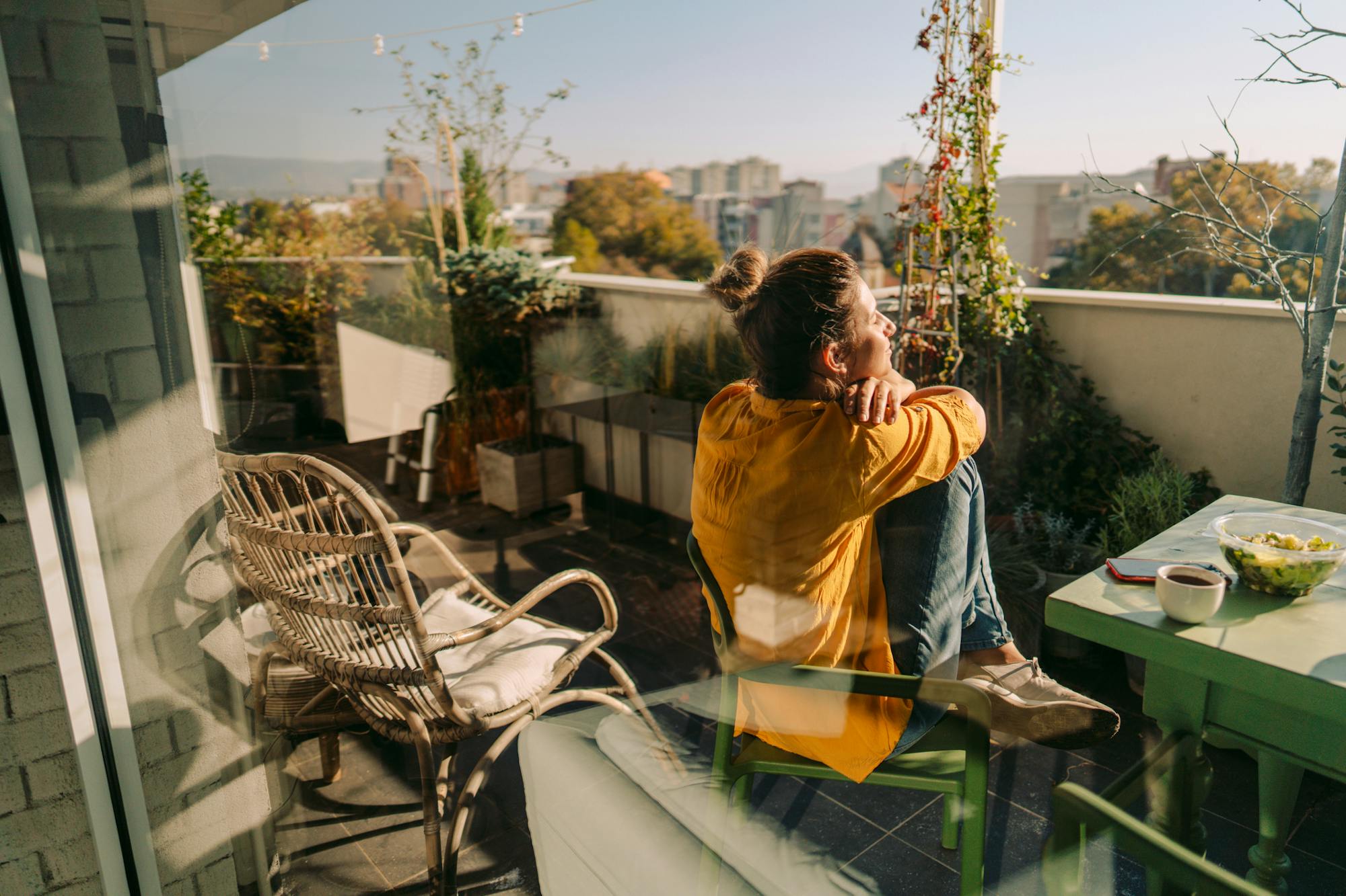 Image of a woman on the balcony of her apartment, representing the need for contents insurance for renters