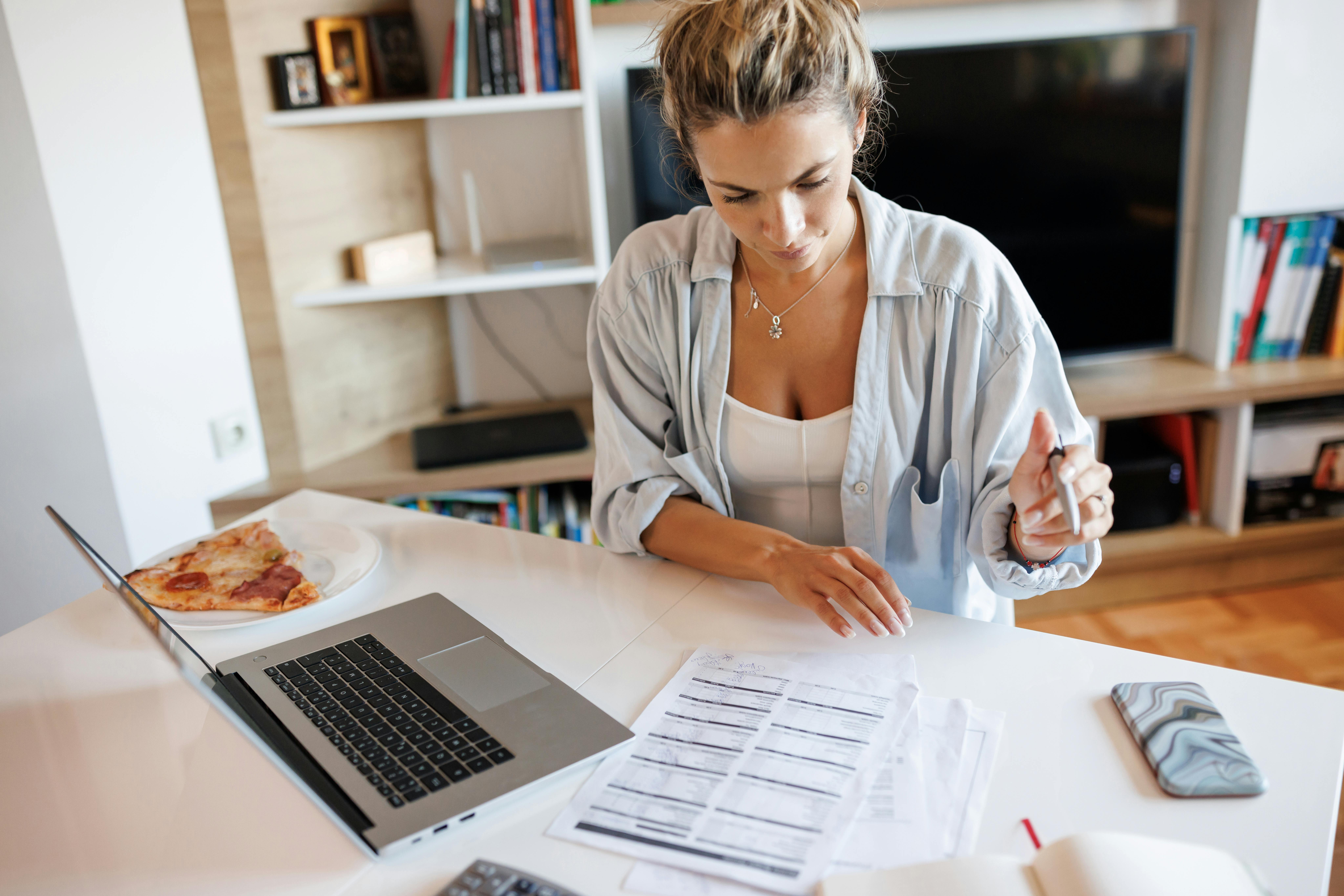 Young woman calculating expenses at home