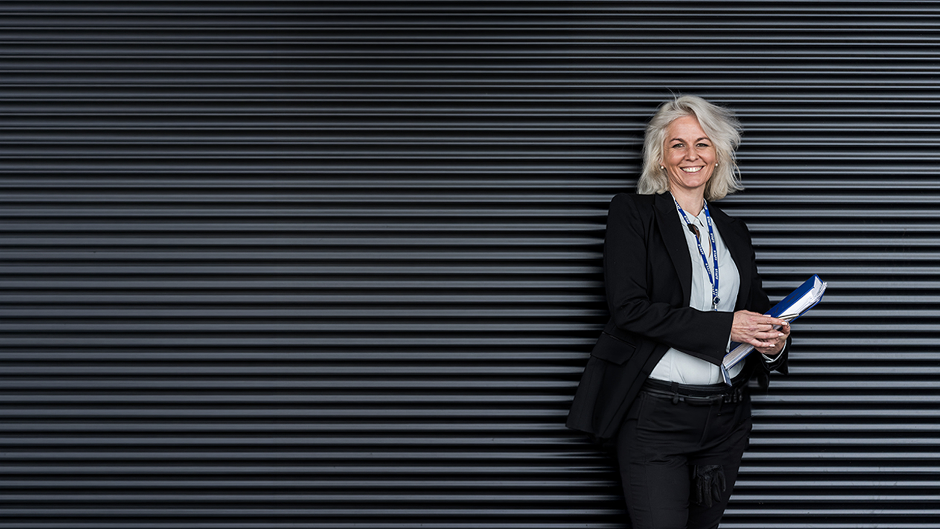 A lady standing against a solid dark background