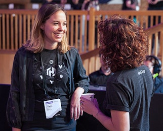 2 employees talking and laughing together at HashiConf 2017.