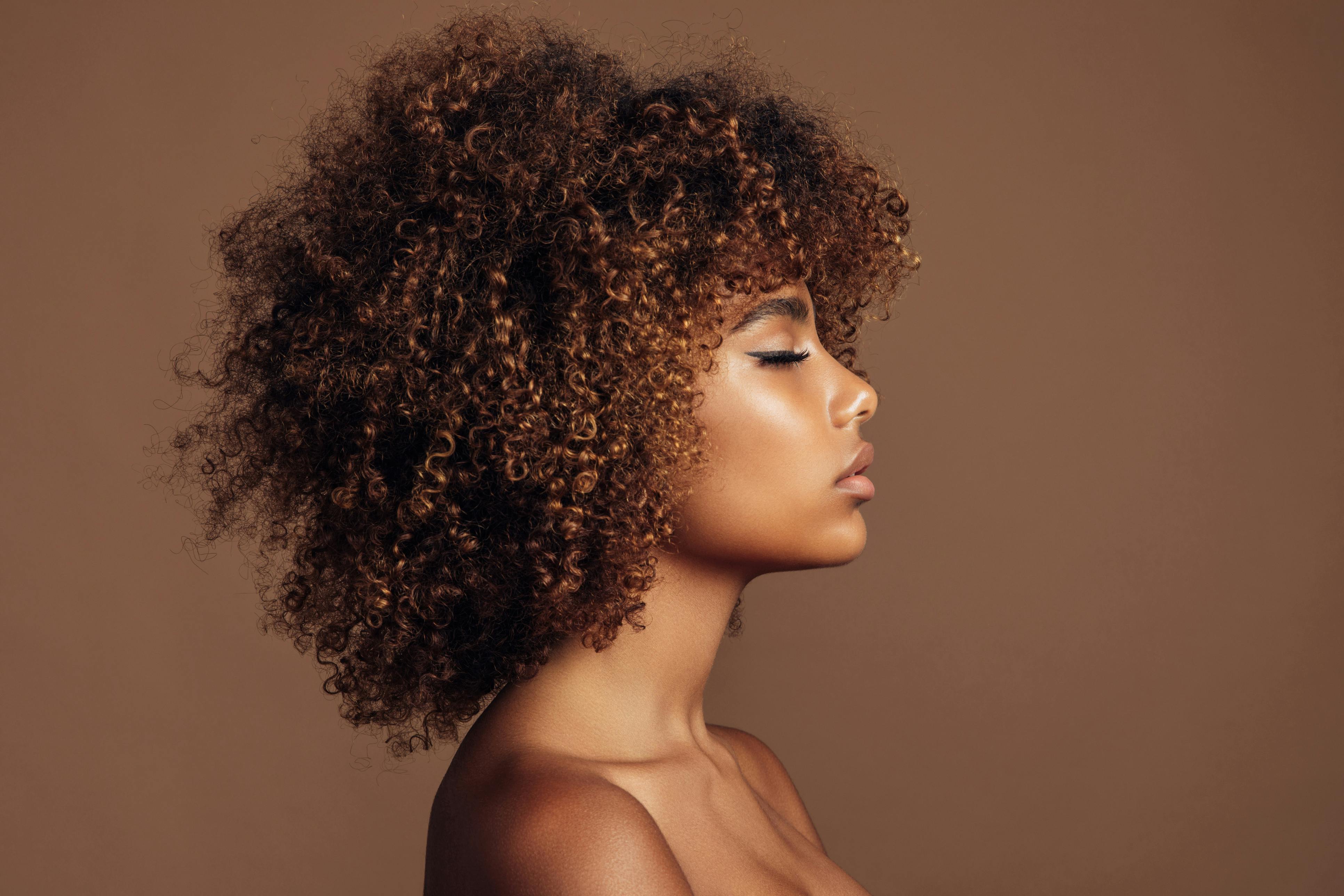 Profile of a woman with curly, brown hair
