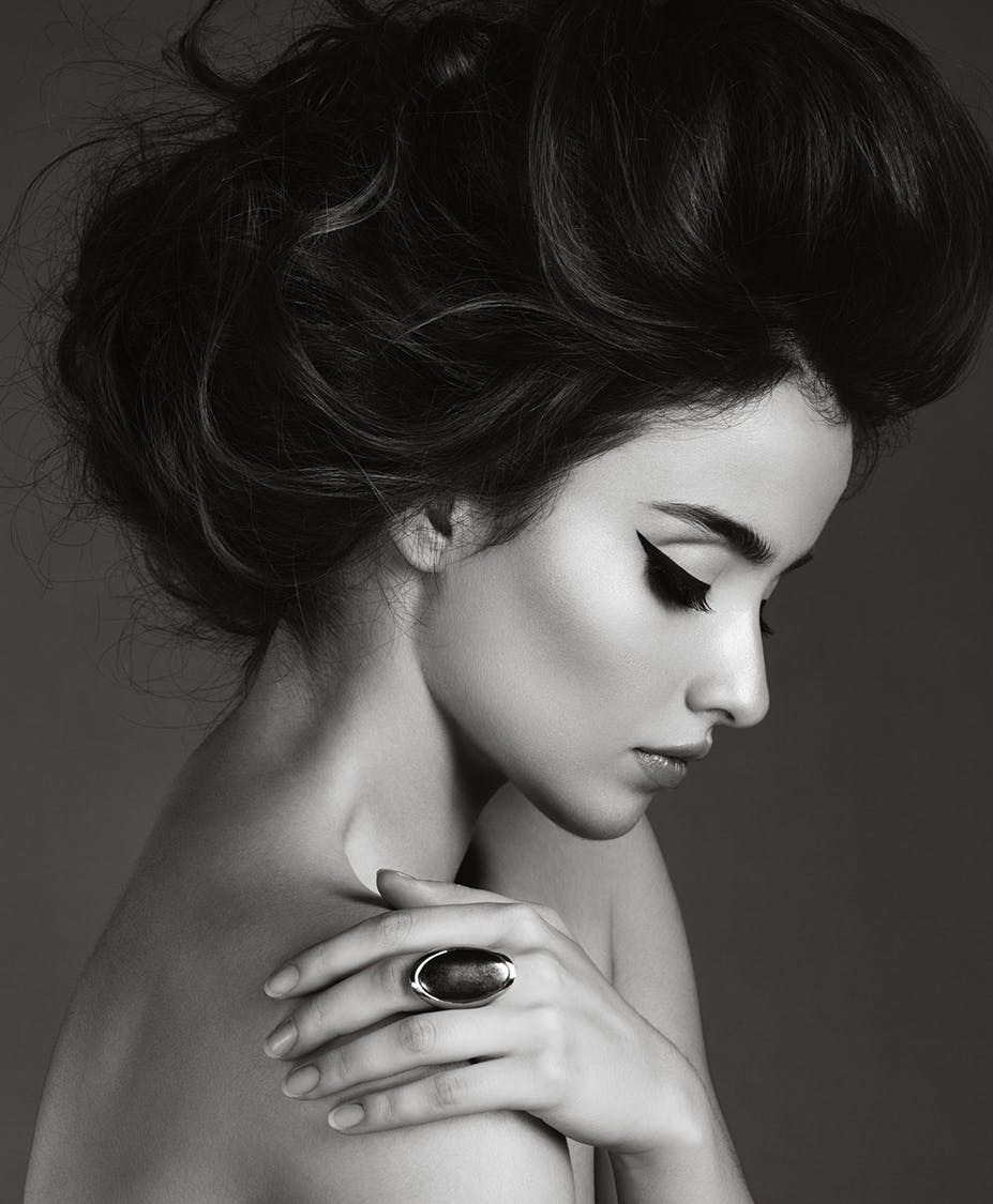 Beautiful woman with winged eyeliner and fancy hair updo