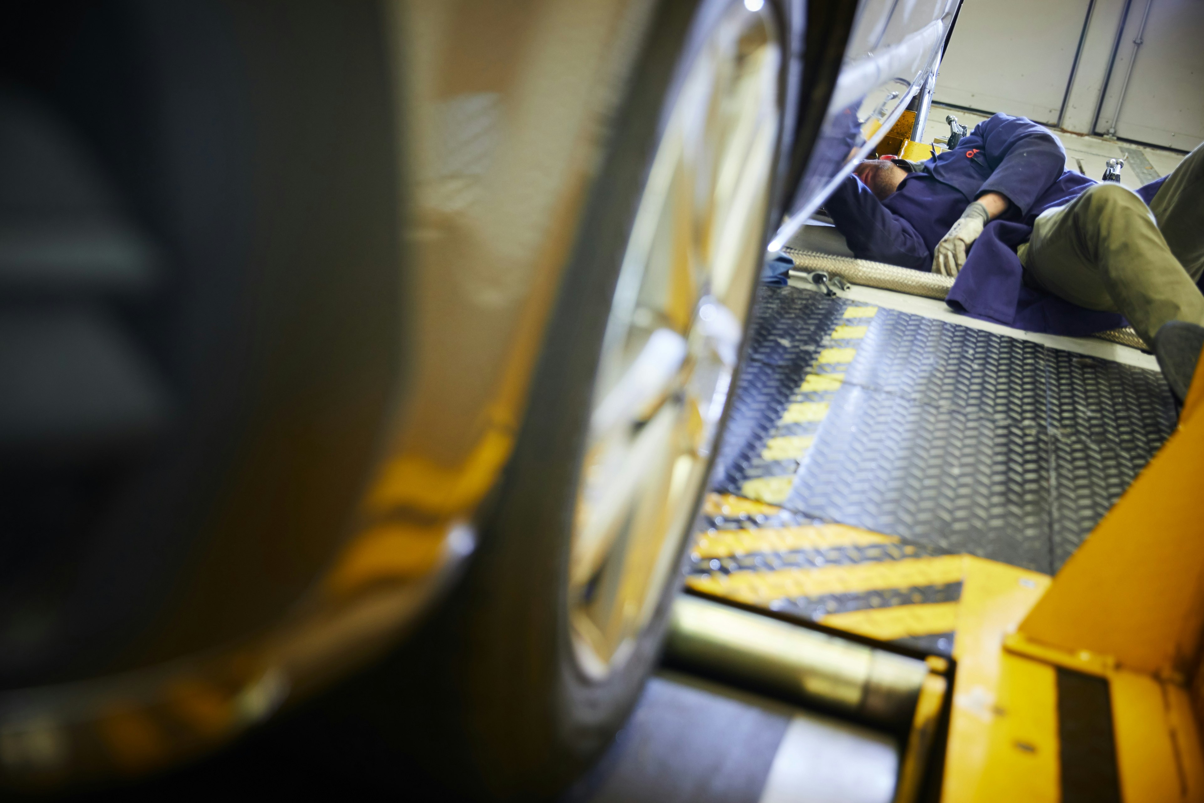 Cambustion engineer working under vehicle on chassis dynamometer 