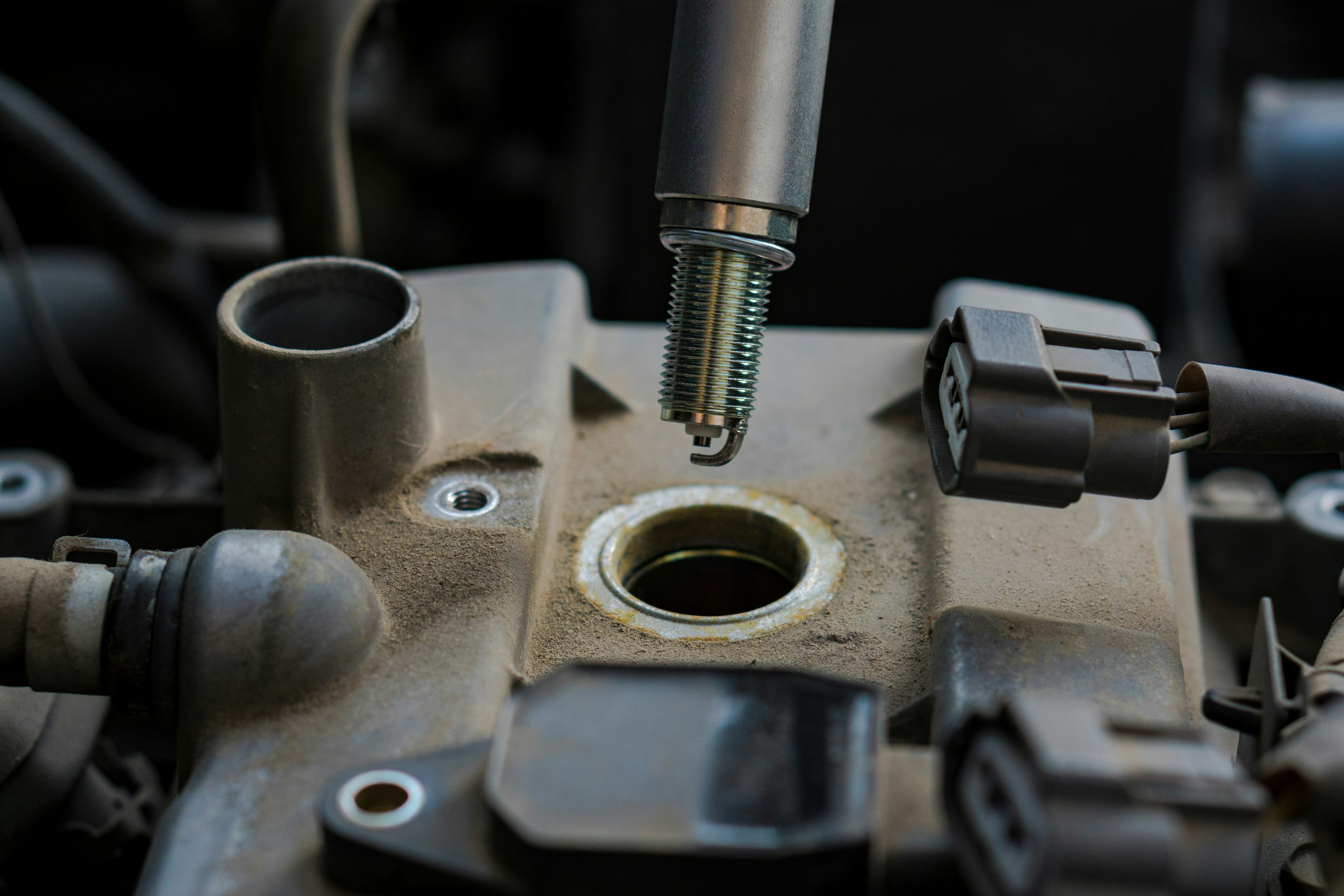 Spark plug being removed from engine