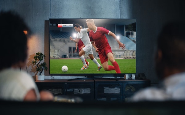 Casal na sala assistindo ao jogo de futebol da Espanha e Inglaterra