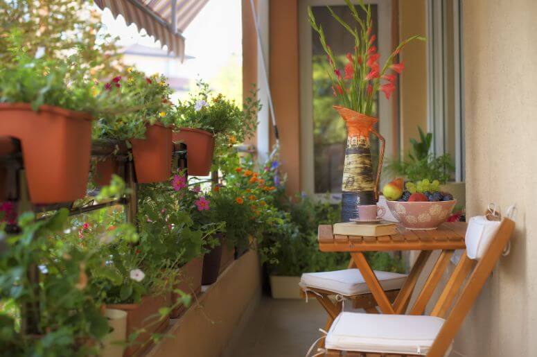 cantinho de leitura na varanda com mesa, cadeira e plantas