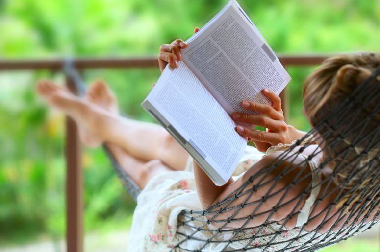 mulher lendo um livro na rede de descanso