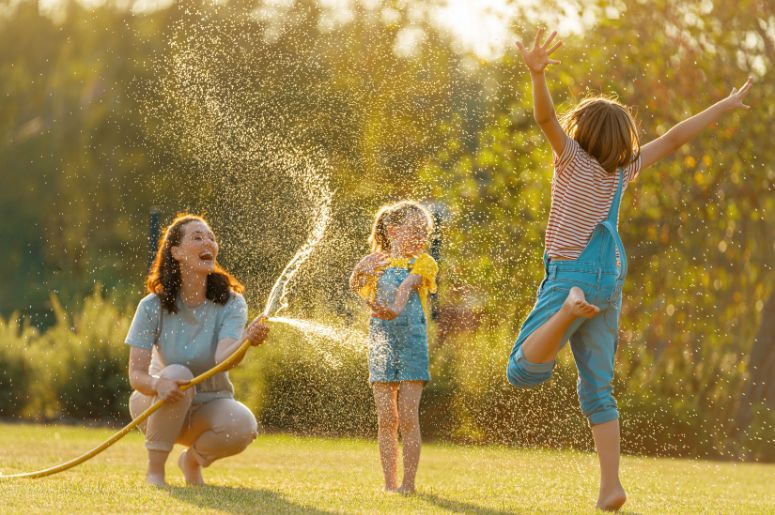mãe e duas crianças brincando no jardim
