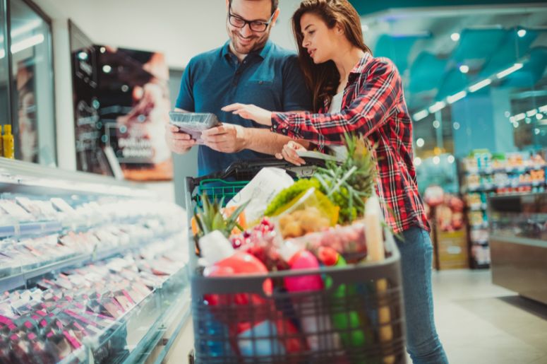 casal no supermercado com carrinho cheio