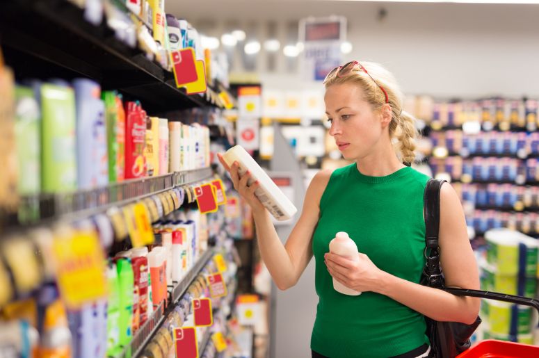 mulher no supermercado comprando shampoo