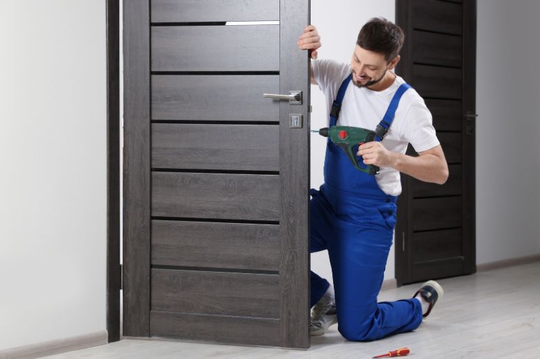 homem instalando a porta de madeira