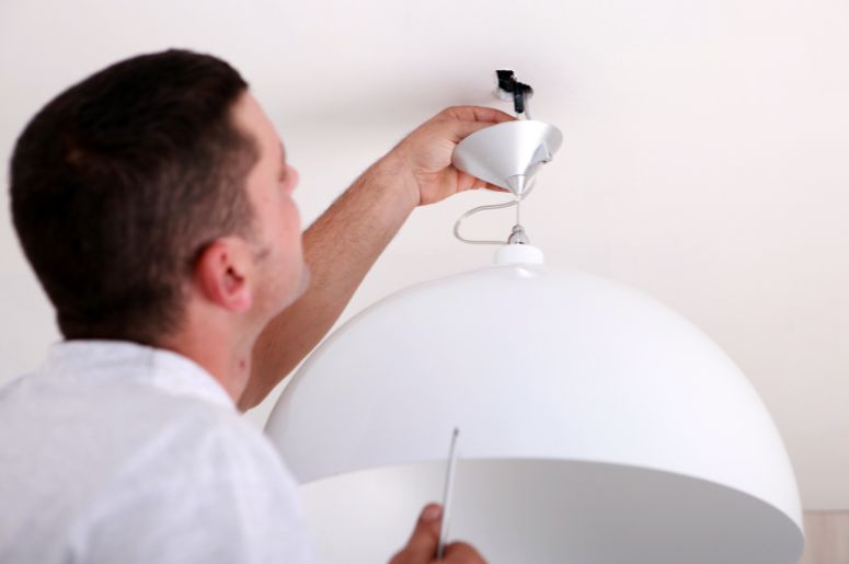 homem instalando a luminária de teto