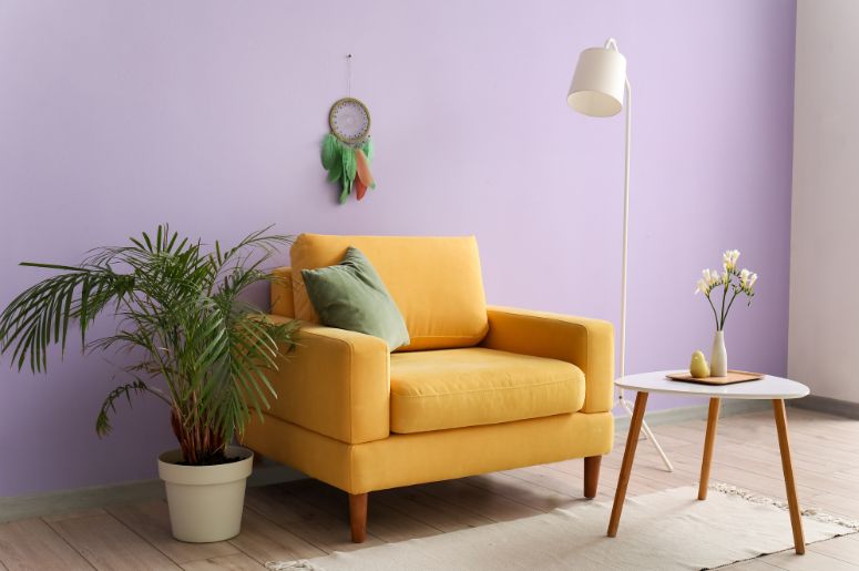 sofá amarelo claro e parede lilás