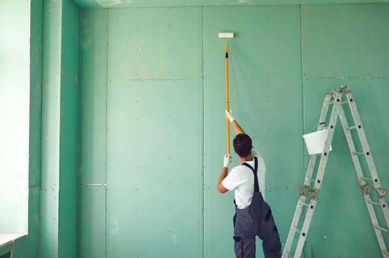 homem pintando a parede de verde