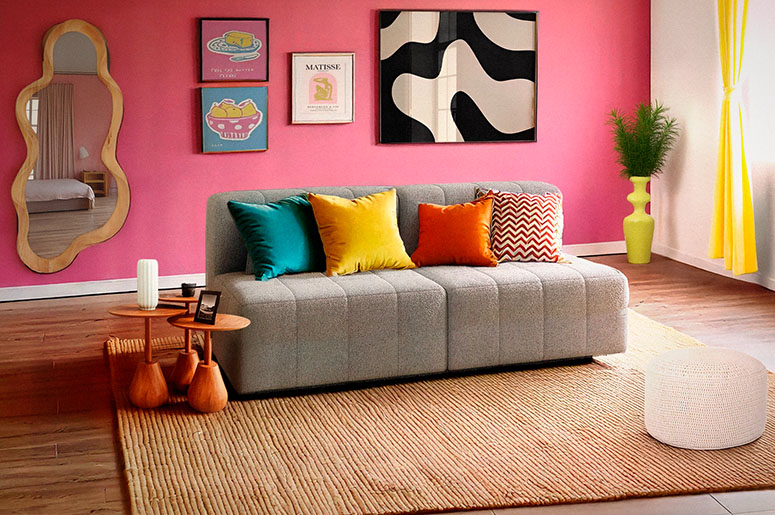 Sala com sofá e parede rosa