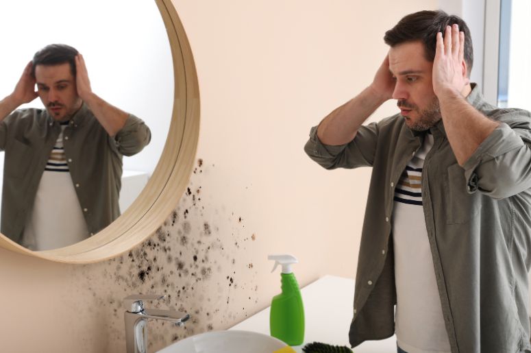homem assustado com umidade no banheiro