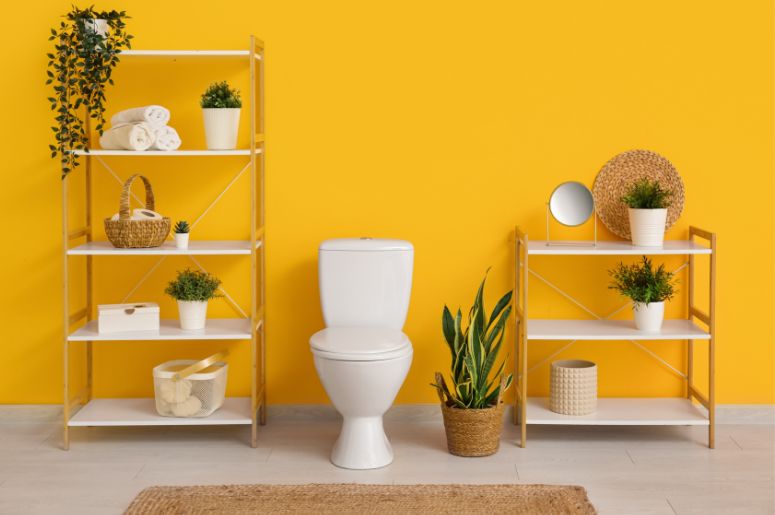 Banheiro com vaso branco e parede amarela