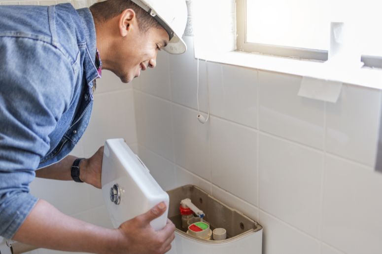 Homem verificando booia do vaso sanitário
