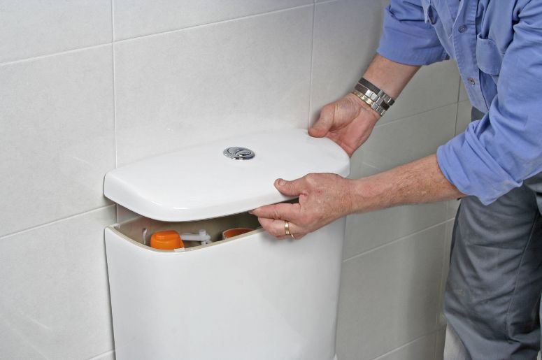 Homem encaixando a tampa do vaso sanitário