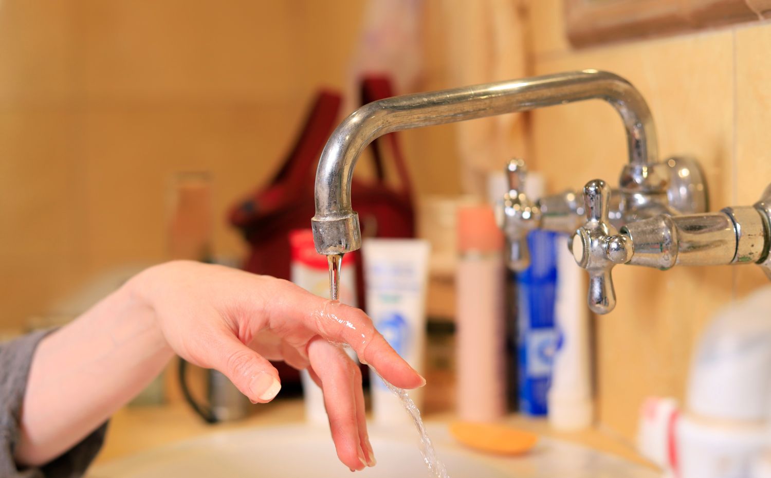 Mulher verificando a baixa press&atilde;o da torneira 