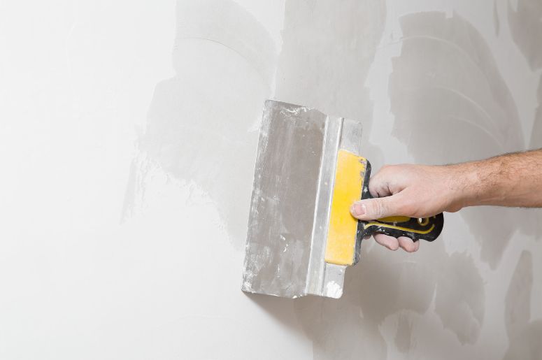 Homem preparando a parede