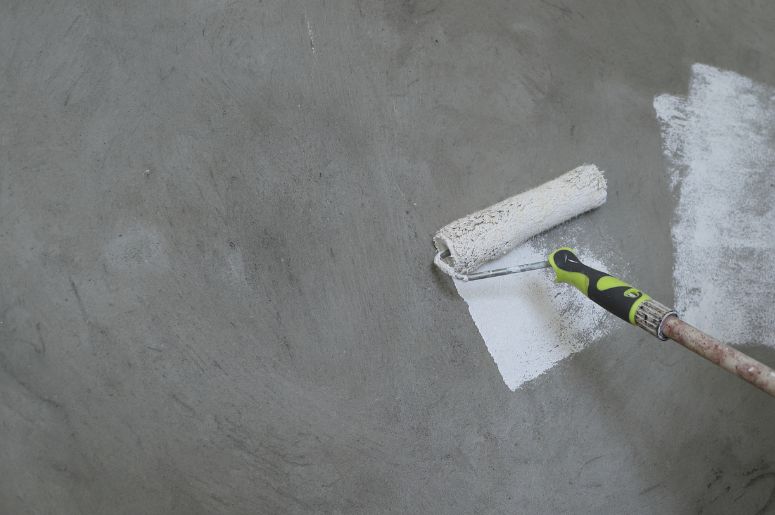 Homem aplicando o selador na parede