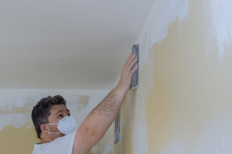 Homem lixando a parede