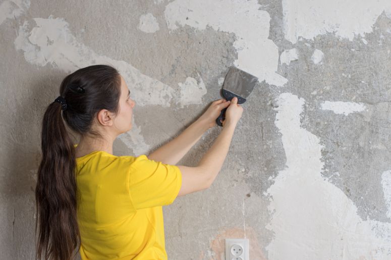 Mulher aplicando massa corrida