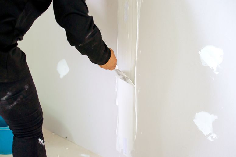 Profissional aplicando massa corrida