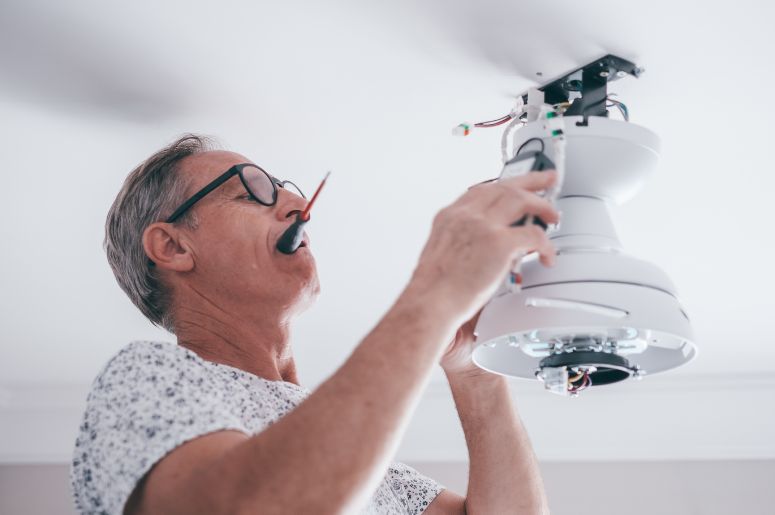 Homem instalando ventilador de teto