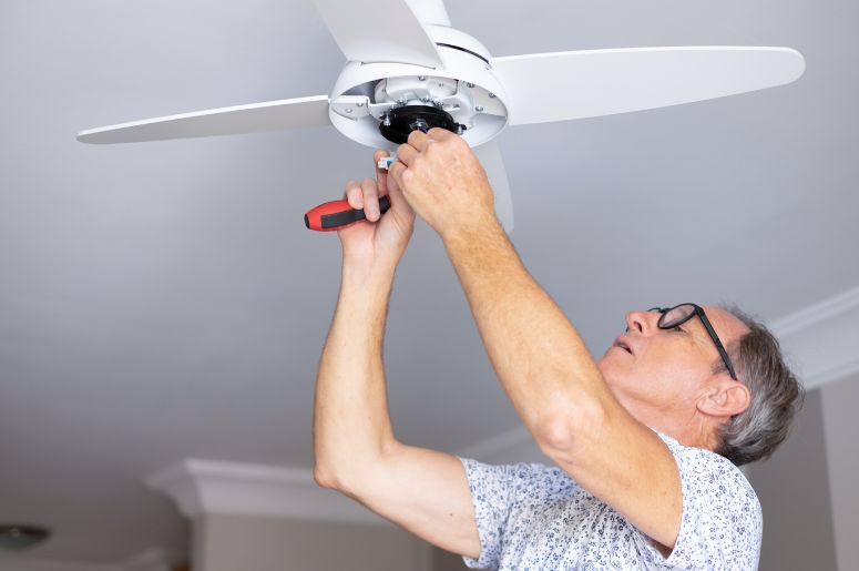 Homem montando ventialdor de teto