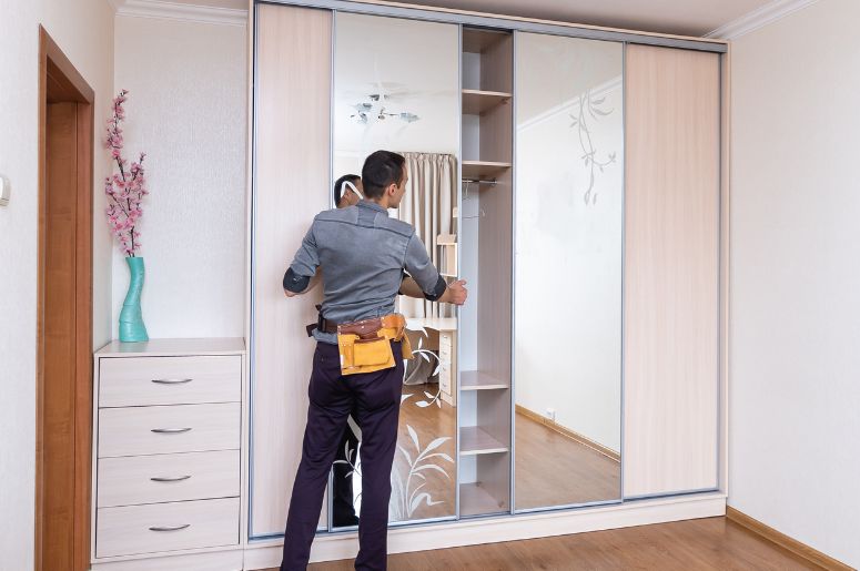 Homem instalando as portas do guarda roupa