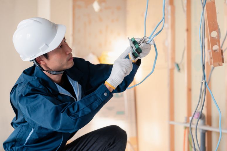 Homem instalando rede el&eacute;trica