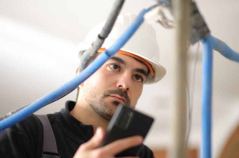 Homem verificando instala&ccedil;&atilde;o el&eacute;trica